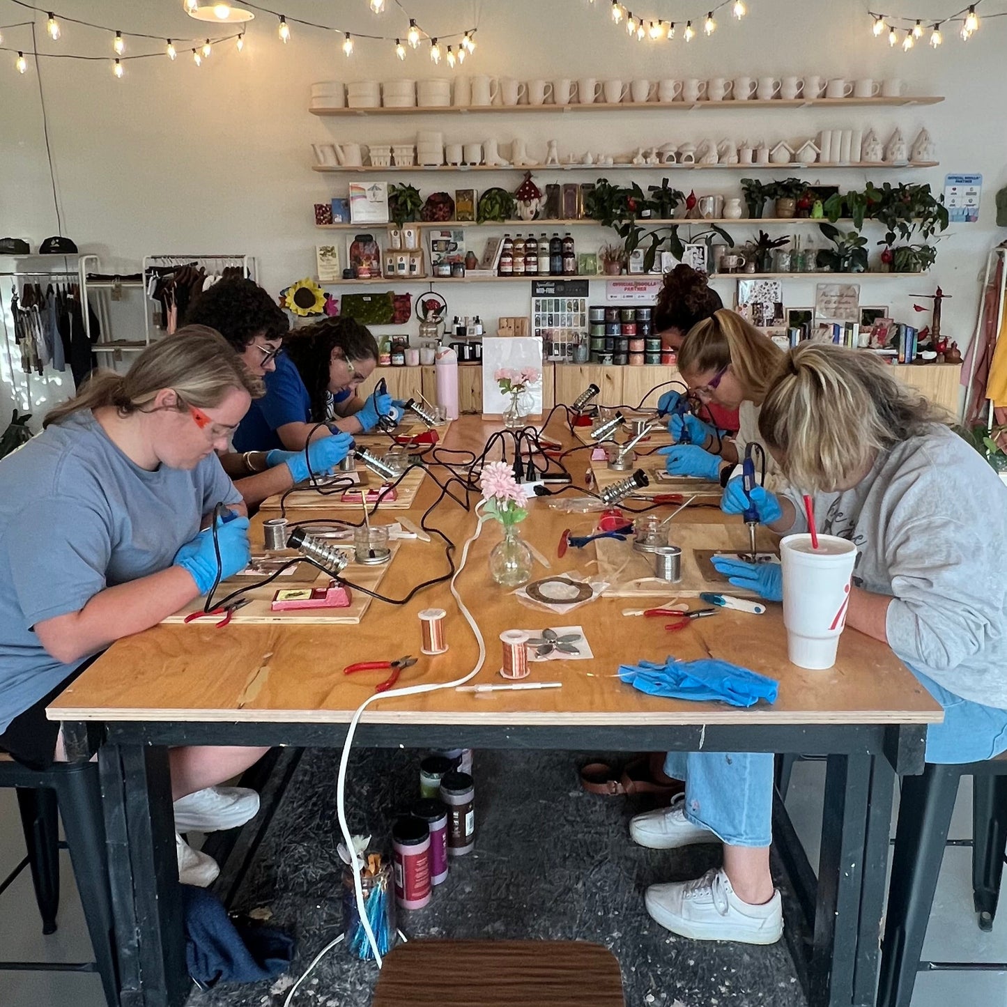 People working at a long table in a workshop or studio setting.